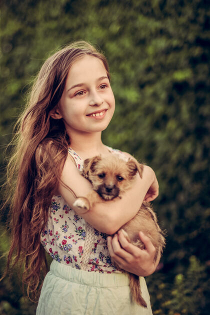 孩子一个金发小女孩带着她的宠物狗在外面停车场女孩喜欢一只小狗家庭动物童年