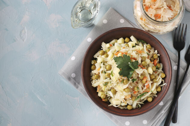餐巾健康沙拉泡菜 豌豆罐头和胡萝卜在一个浅蓝色的表面碗 顶视图 复制空间开胃菜厨房乡村