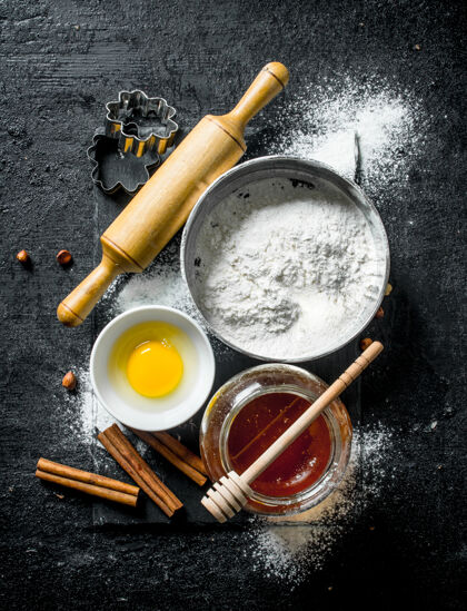 准备烘烤背景.面粉加蜂蜜 肉桂和蛋蛋黑色乡村背景蛋糕器皿鸡蛋