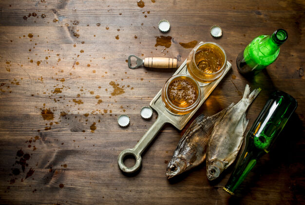 黄色把几杯啤酒放在架子上晾干鱼开木制背景菜有机酒精