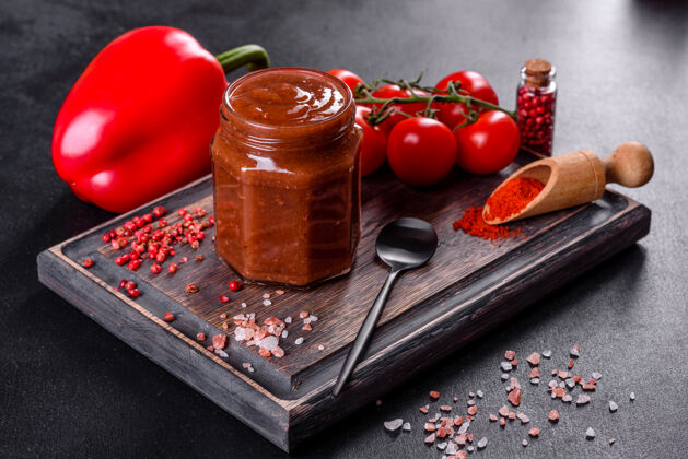 碗格鲁吉亚菜的辛辣调味料阿吉卡在一个碗里 用红辣椒和大蒜放在混凝土桌上特写镜头辣椒美味蔬菜
