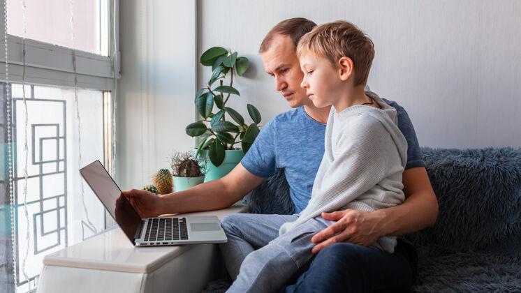 居家父子俩用笔记本电脑与爷爷奶奶进行视频通话留守在家 远程沟通的理念年轻人距离笔记本电脑