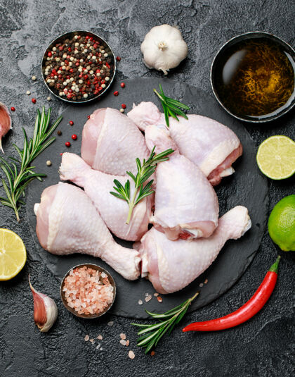 家禽生鸡腿 用香料和配料在砧板上烹饪晚餐食谱胡椒粉