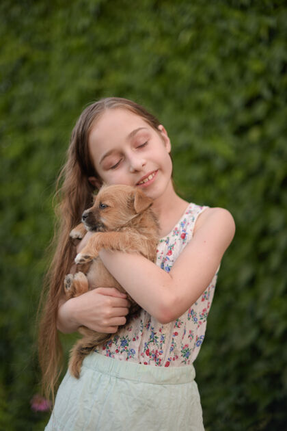 户外一个金发小女孩带着她的宠物狗在外面停车场女孩喜欢一只小狗孩子动物友谊