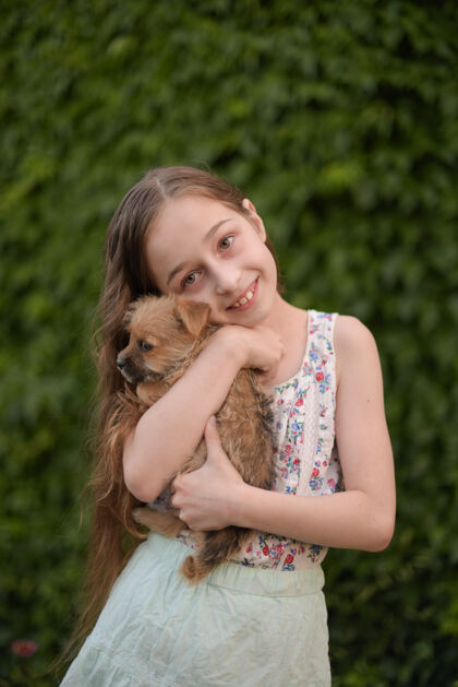 户外一个金发小女孩带着她的宠物狗在外面停车场女孩喜欢一只小狗动物女孩家庭