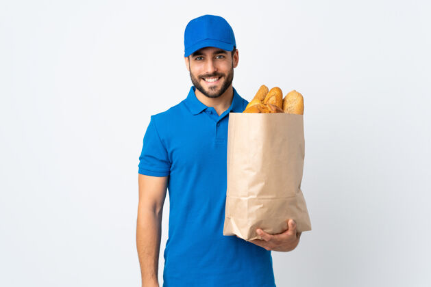 食物送货员手里拿着一袋面包 隔着白色的背景笑了很多微笑好商务