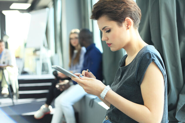 模糊用现代智能手机描绘年轻女商人手女孩阳光工作过程中的短信阅读办公室.水平变模糊分析职业手机