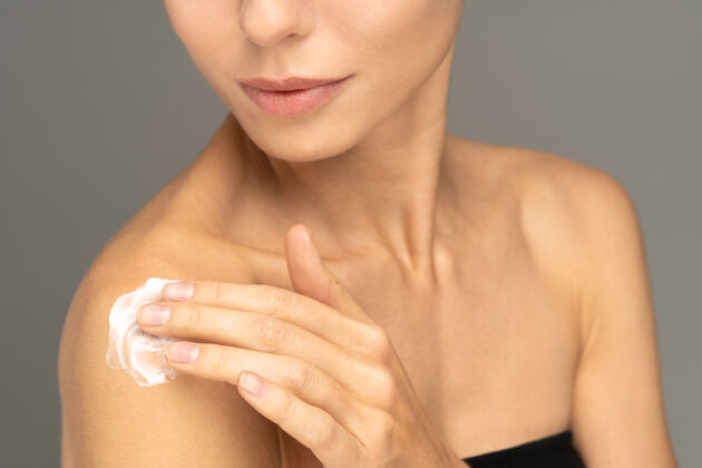 涂抹女人涂防晒霜或化妆品保湿乳液完美保湿皮肤上的肩膀肩膀治疗健康