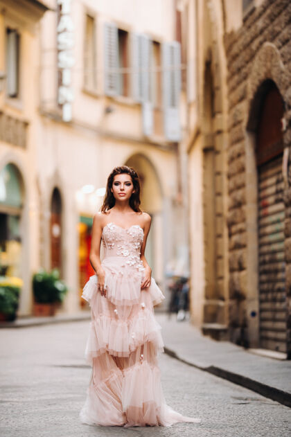 佛罗伦萨美丽时尚的少女模特身着粉色婚纱在佛罗伦萨拍摄 手拿一束不同寻常的花束 新娘模特手拿一束花束 在佛罗伦萨拍摄新娘会年轻模特意大利新娘
