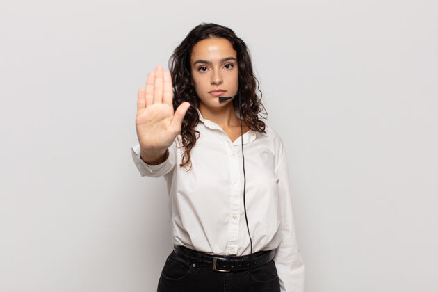 冲突年轻的拉美裔女子表情严肃 严厉 不高兴和愤怒 显示出张开手掌作出停止的手势业务女性女性