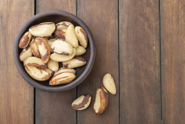 蛋白质巴西坚果放在木桌上的盘子里贝壳天然健康
