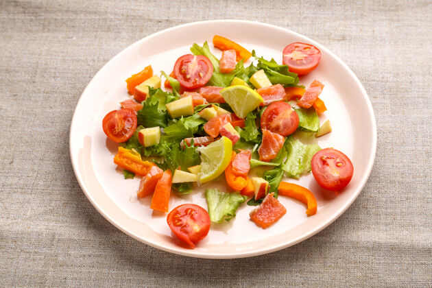 低热量三文鱼沙拉配樱桃番茄和绿色沙拉 放在一盘灰色桌布里开胃菜新鲜菠菜
