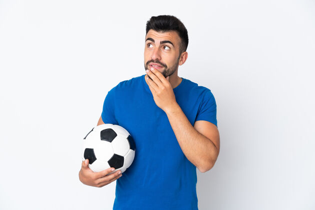 专业年轻帅气的足球运动员翻过隔离墙 微笑着抬起头来西班牙裔比赛球