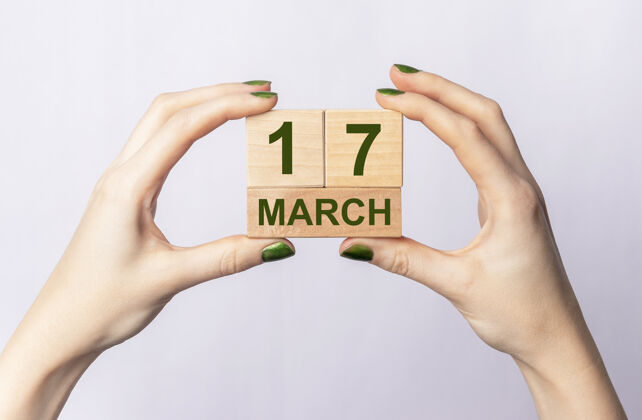 手3月17日女性手上的木制日历上的铭文铭文字爱尔兰