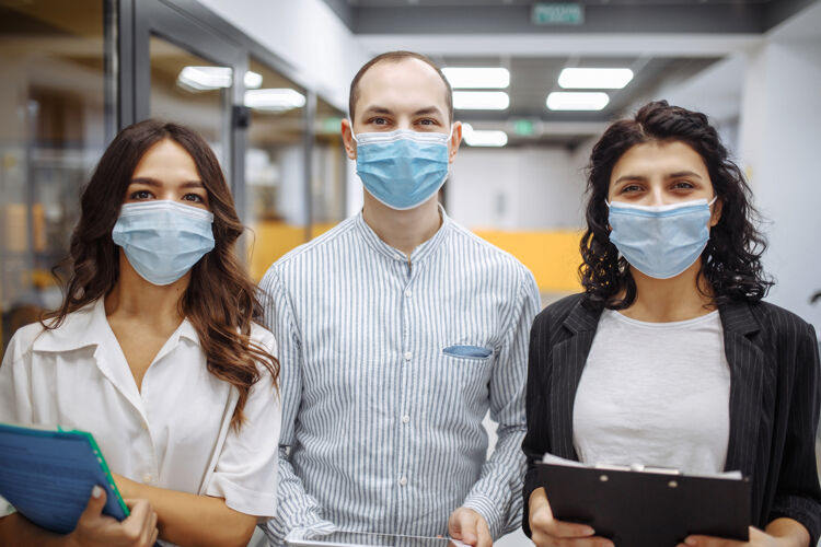 同事三个戴着医用口罩的上班族的画像 讨论着生意和未来的前景成长感染流行病