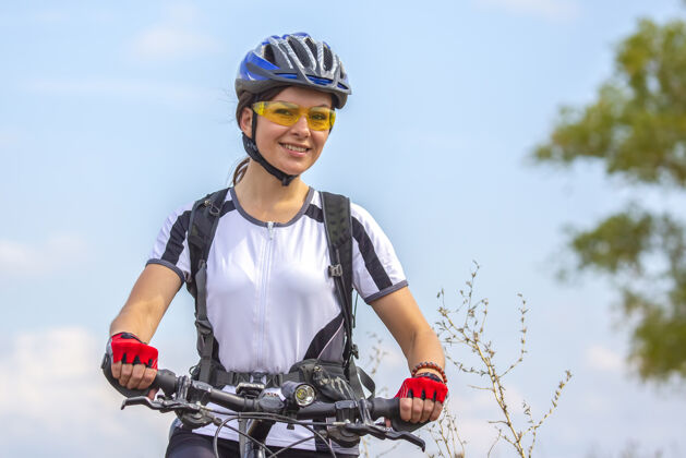 道路骑着自行车的美丽快乐的女自行车手自然健活方式和运动休闲和爱好公园小径骑行