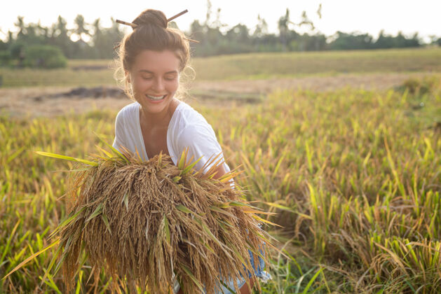 乡村生态旅游还是日常生活工作快乐女农场主在稻田收割草地夜晚手臂