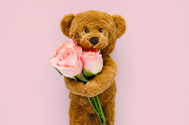 节日泰迪熊拿着粉红色的玫瑰熊花束日子