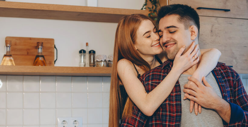 男人可爱的有雀斑的姜汁女孩在厨房拥抱她的爱人爱抚家庭人类