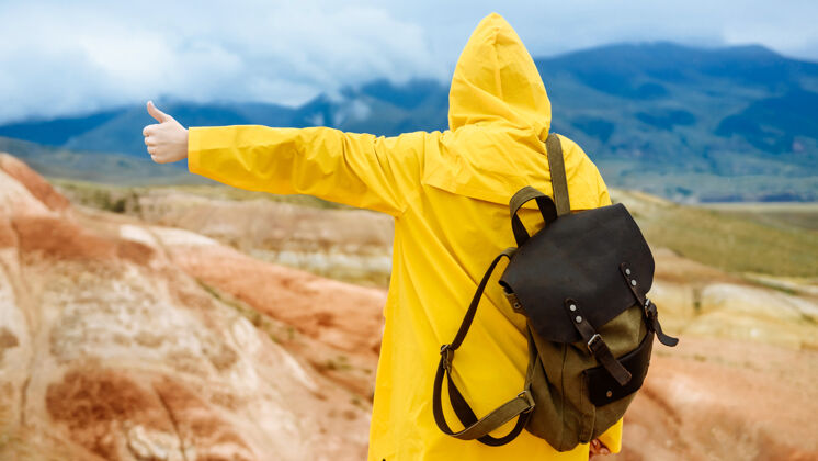 休闲中国山区雨中背着背包的女徒步旅行者秋季旅行还有度假的概念女人小径女