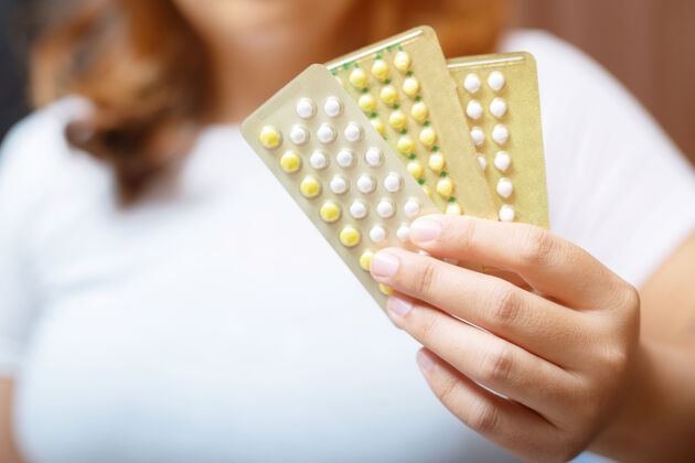 怀孕妇女在家里打开避孕药手吃东西避孕药口服日医学