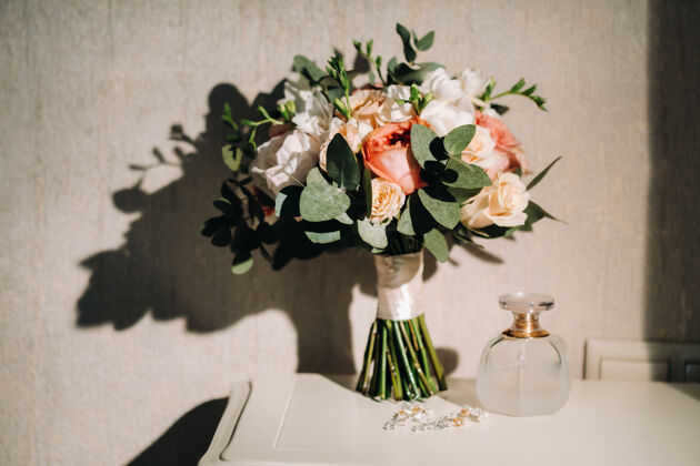 自然桌上摆着玫瑰的婚礼花束礼物面纱优雅