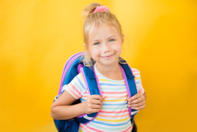背包黄色墙上一个带着背包微笑的小女生的画像学习知识女学生