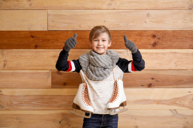 衣服可爱的小男孩 穿着冰鞋 拇指向上靠在木头上鞋子鞋子手势