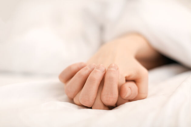 休息睡在床上的年轻夫妇的手手感觉休闲