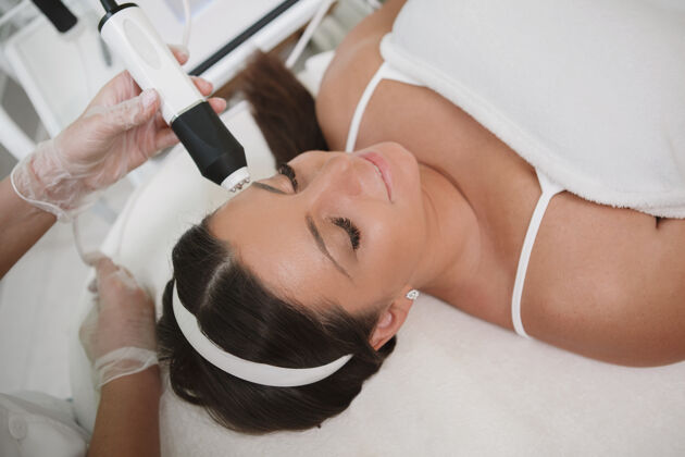 皮肤护理放松的女人享受专业美容美容师的面部护理护理皮肤科健康