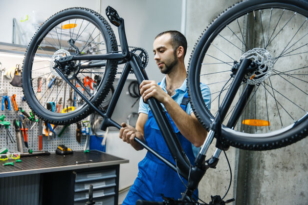 自行车在车间修理自行车 人检查机械装置工具手链条