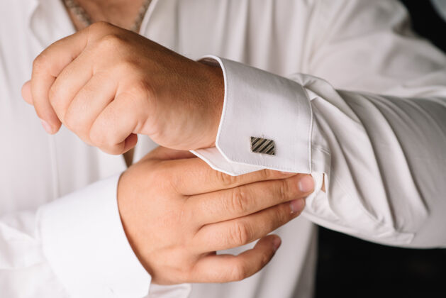 男士穿白衬衫的人穿上袖扣.商务着装要求人感情婚礼