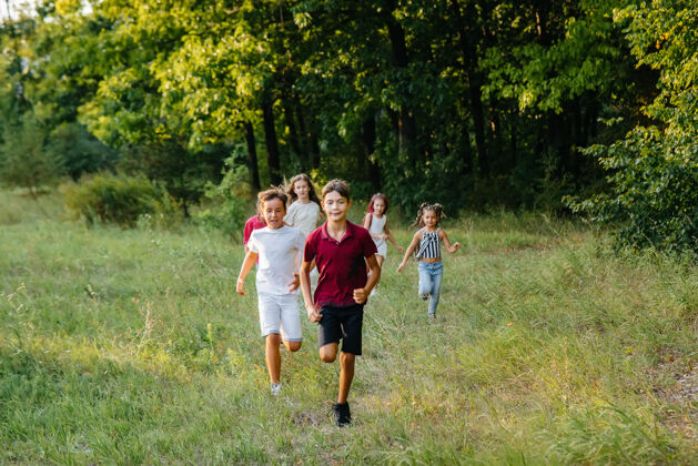 朋友日落时分 一群快乐的孩子在公园里奔跑玩耍孩子小学生青年
