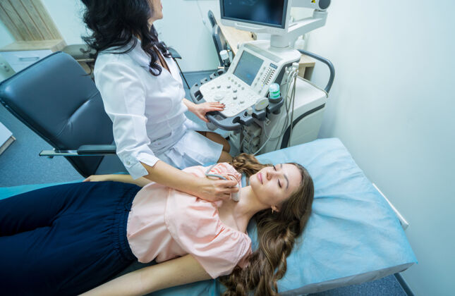 治疗医生用超声波扫描仪检查一个女人的甲状腺医学医生疾病