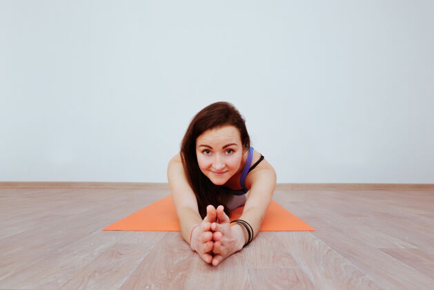 瑜伽女人在橙色的垫子上做瑜伽练习 伸展姿势平衡垫子
