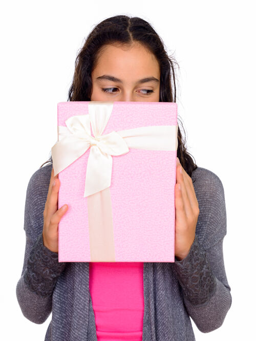 礼物年轻漂亮的少女躲在礼品盒后面 与白色空间隔离青少年漂亮头发