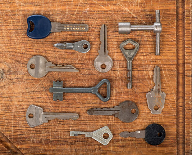 分类许多各式各样的旧多色金属古董钥匙不同形状的木制刮擦表背景钥匙门解锁