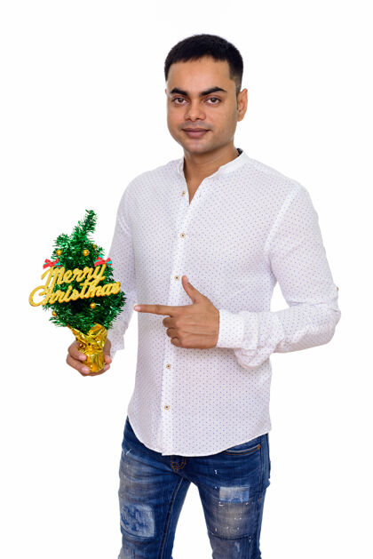 手指年轻英俊的印度商人为圣诞节做好了准备 与白色空间隔绝季节指向20岁