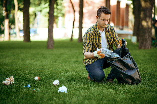 垃圾年轻人在公园里用袋子收集垃圾 志愿服务男人清林 生态修复 生态生活方式 垃圾收集回收 生态关爱 环境清洁塑料人容器