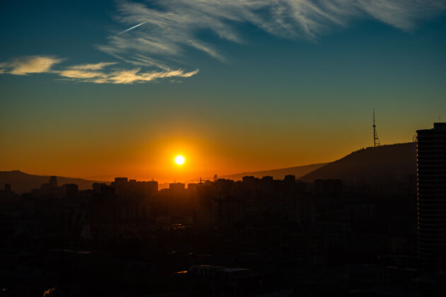 城市第比利斯市中心的日出时间 明亮的蓝天和红色的太阳太阳上升日出