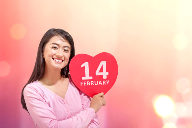 女人亚洲女子手持红色心形2月14日标志和彩色墙情人节礼物天哪泰语一起团聚
