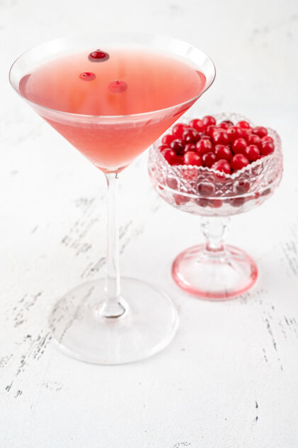 玻璃杯一杯带有新鲜小红莓的国际鸡尾酒浆果明亮酸橙