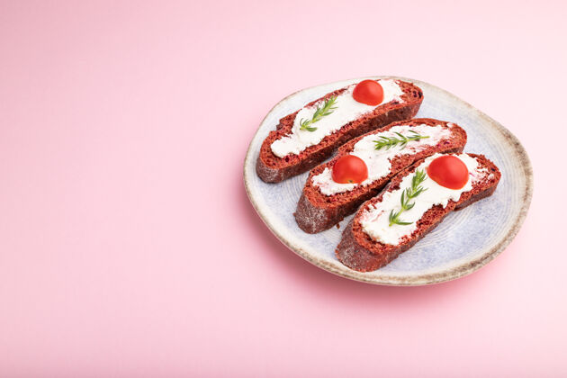 陶瓷红色甜菜面包三明治 奶油奶酪和西红柿 粉粉色表面美味香草复制空间
