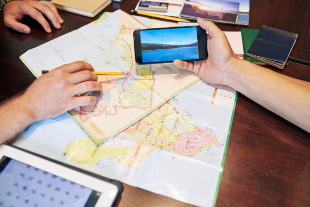 秩序当他的朋友在智能手机上展示这个地方的照片时 他指着海岸地图桌子合作地图