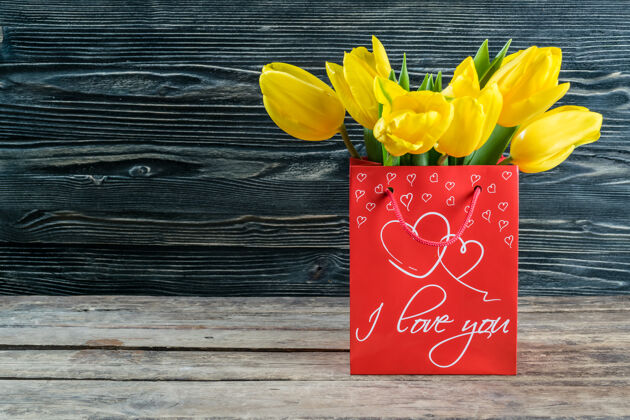 桌子节日明信片与郁金香花彩色木背景 花边香气花瓣自然