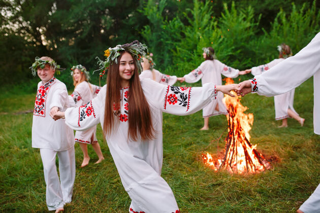 田野仲夏年轻穿着斯拉夫人衣服的人在盛夏围着火转女性乡村假日