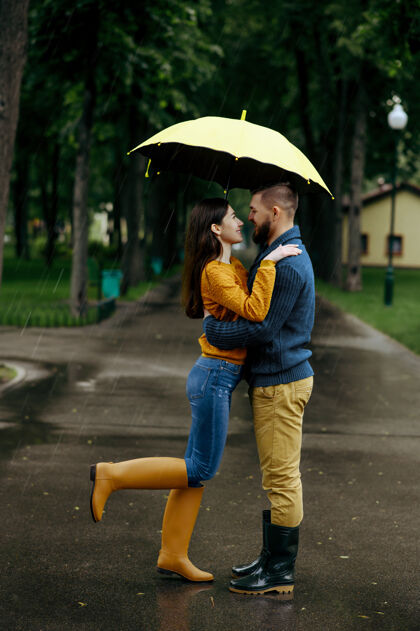 天气情侣在公园接吻 夏天下雨戴曼雨中的女人站在雨伞下 漫步小径上的浪漫约会 小巷里的潮湿天气年轻约会家庭