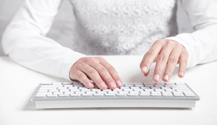 桌子在办公桌上用电脑键盘打字的女孩忙碌通信房子