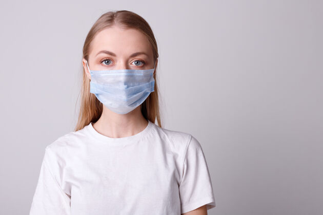 冠状病毒戴着医用面具的女孩站在灰色的墙上防护预防流感