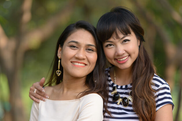 关系两位亚洲年轻女性在公园户外放松的写真女同性恋风景泰国